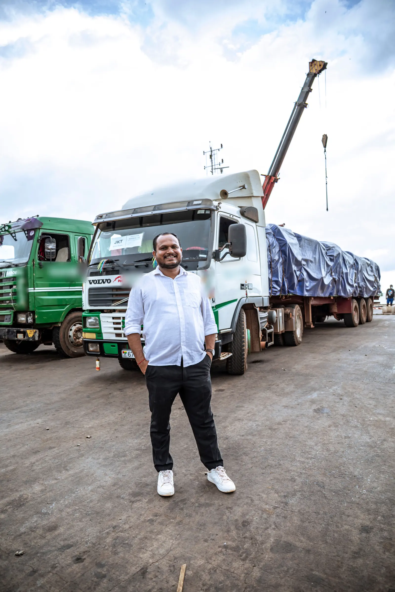 The director of Bafata Agri Resources standing on the quay in front of the loaded fleet, with the ship's crane behind him.